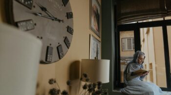woman in gray and white stripe shirt sitting on couch