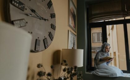 woman in gray and white stripe shirt sitting on couch